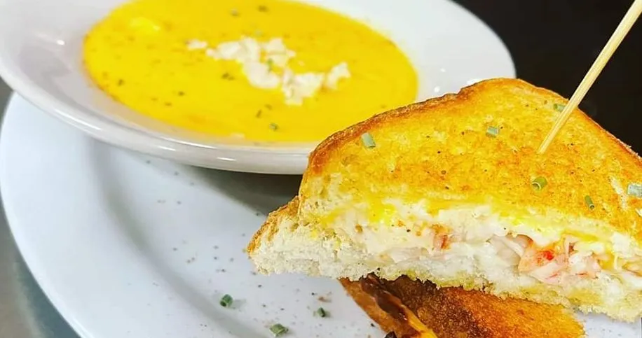 A hot bowl of lobster bisque with a creamy lobster grilled cheese for $14.99